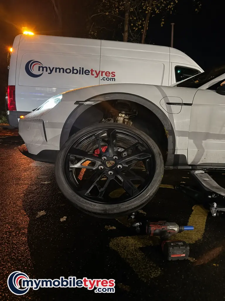 Mobile tyre fitter working on a car tyre in Kingston Upon Thames