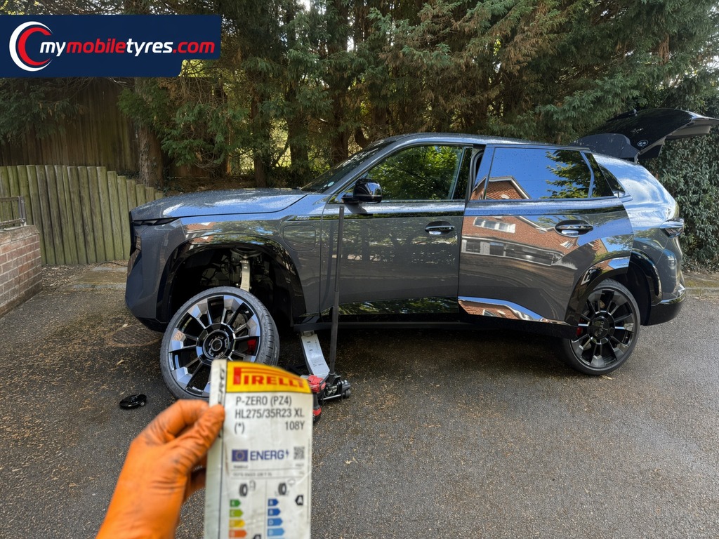 Mobile tyre fitter replacing a flat tyre at the roadside in London & the South East