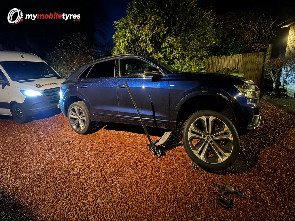 Mobile tyre fitter replacing a flat tyre at the roadside in London & the South East
